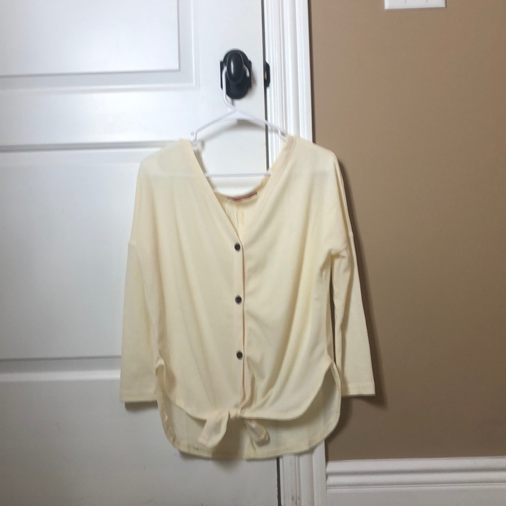 A cream colored buttoned down shirt